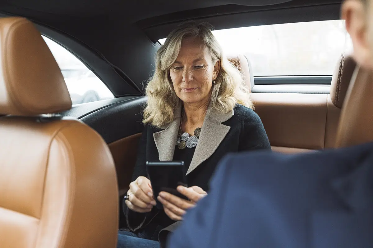 Professional business woman working on tablet in luxury corporate chauffeur service Mercedes-Benz in London